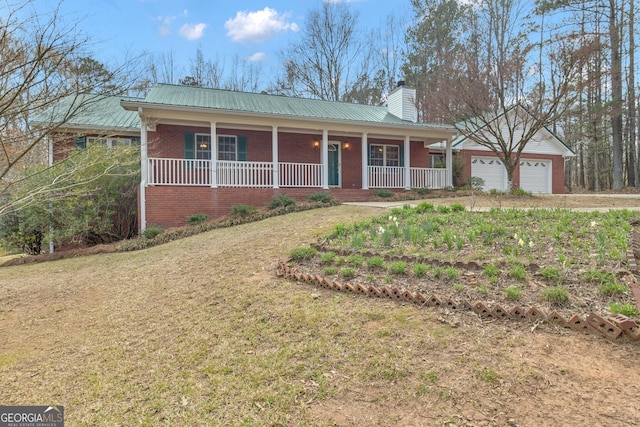 ranch-style house with covered porch, metal roof, brick siding, and a chimney