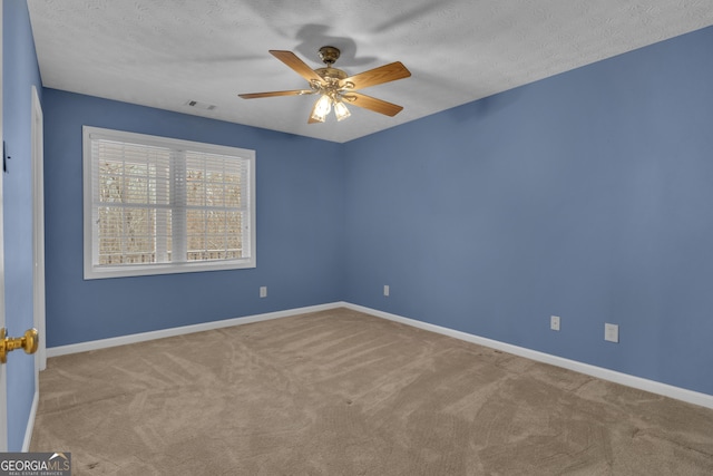 carpeted empty room featuring visible vents, ceiling fan, a textured ceiling, and baseboards