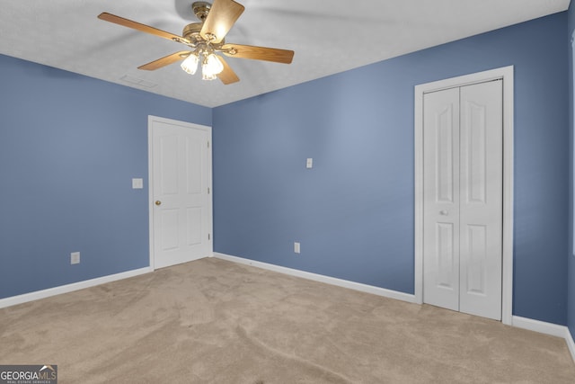 unfurnished bedroom with carpet floors, a closet, a ceiling fan, and baseboards