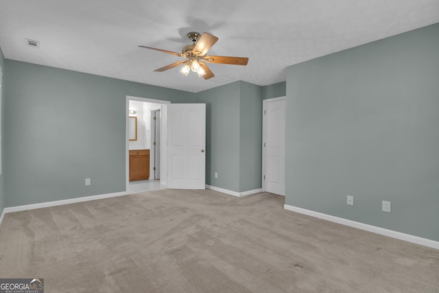 unfurnished bedroom with light carpet, baseboards, visible vents, connected bathroom, and ceiling fan