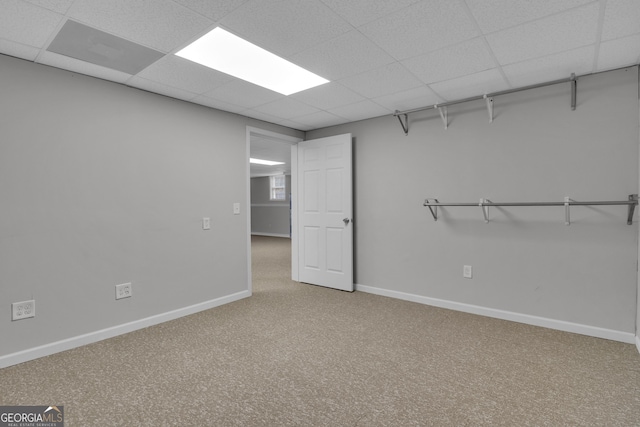 interior space with a drop ceiling and baseboards