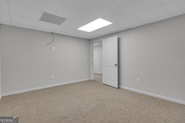 below grade area featuring carpet floors, baseboards, and a drop ceiling