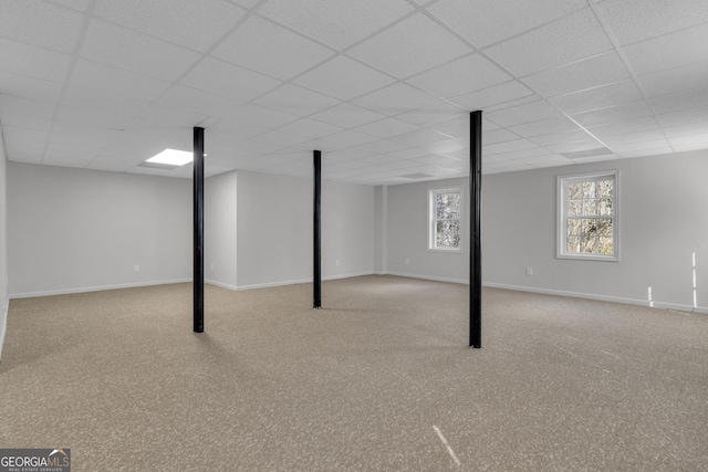 basement featuring baseboards and a drop ceiling