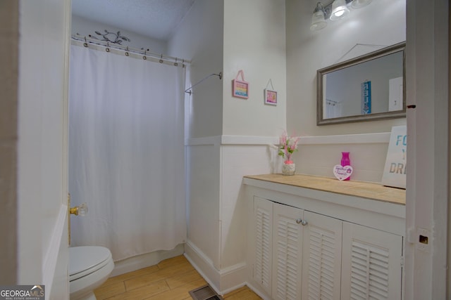 full bathroom featuring visible vents, wainscoting, toilet, wood finished floors, and shower / bath combo with shower curtain