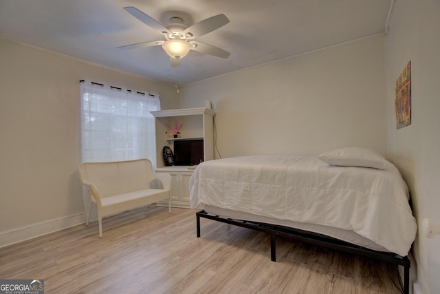 bedroom with ceiling fan, baseboards, and light wood-style floors