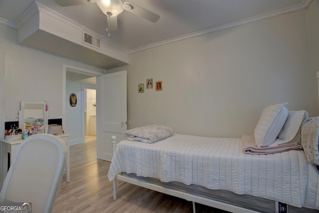 bedroom with ornamental molding, visible vents, light wood-style floors, and a ceiling fan