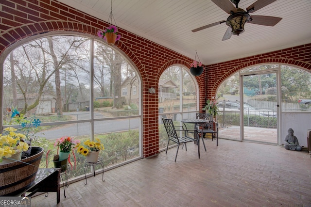 unfurnished sunroom featuring plenty of natural light and ceiling fan