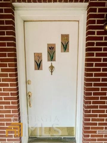 doorway to property with brick siding