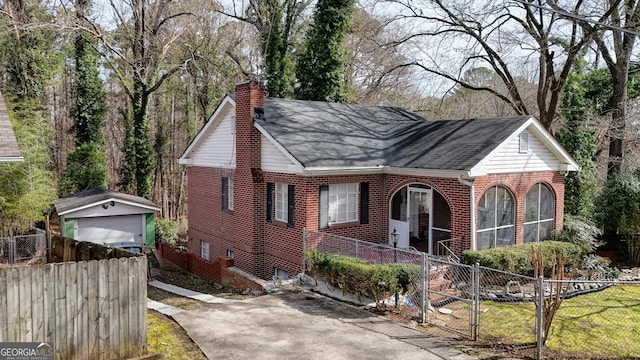 view of front facade with brick siding, a fenced front yard, and a chimney