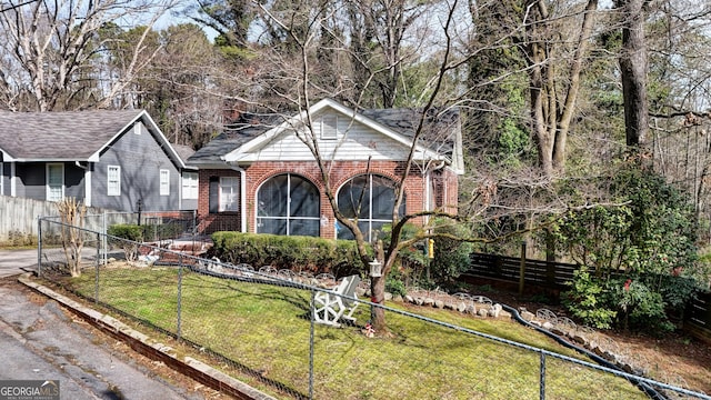 view of front of house featuring a front yard, fence, and brick siding