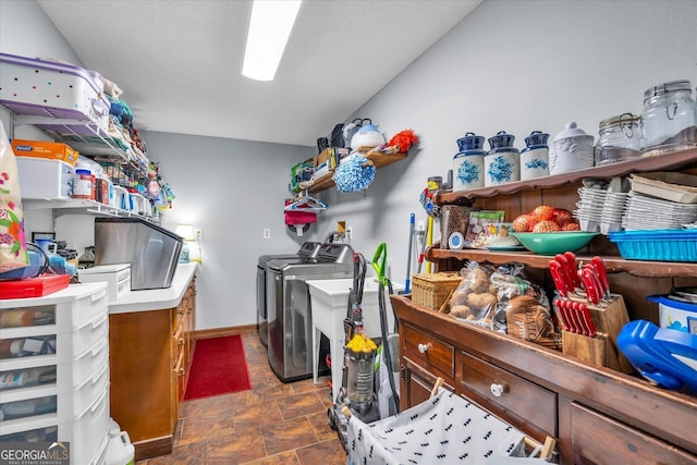 washroom featuring baseboards, laundry area, washing machine and dryer, and stone finish flooring