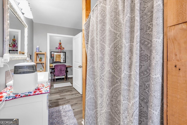 full bath with wood finished floors and a shower with shower curtain