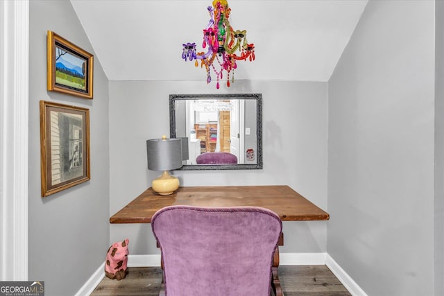 office area with lofted ceiling, baseboards, wood finished floors, and built in study area