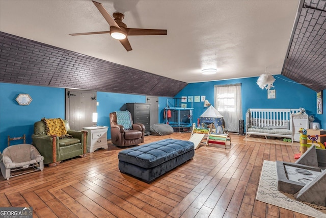 recreation room with ceiling fan, vaulted ceiling, and wood finished floors