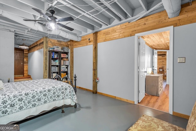 bedroom with a ceiling fan, finished concrete flooring, and baseboards