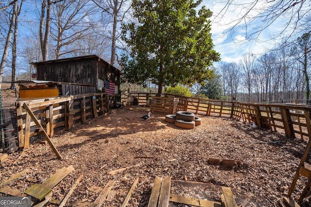 view of yard featuring an outdoor structure and fence