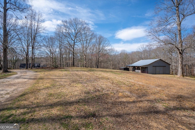 view of yard with an outbuilding, a pole building, and a detached garage