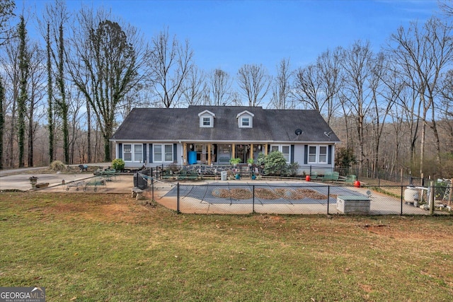 cape cod house featuring a patio, a front yard, fence, and a fenced in pool