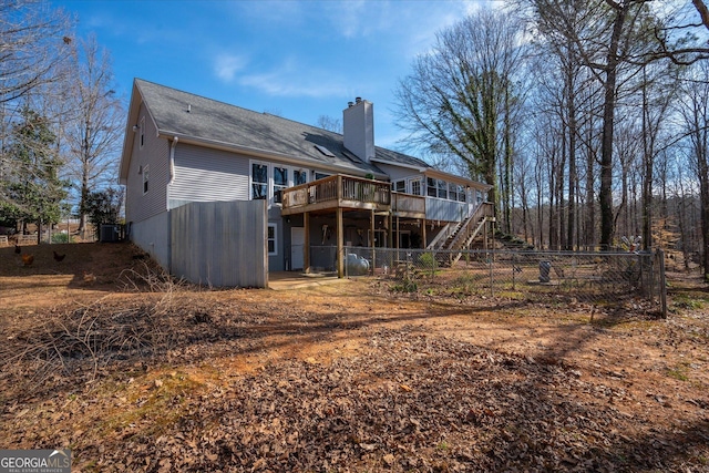 rear view of property featuring stairway, a chimney, fence, and a wooden deck