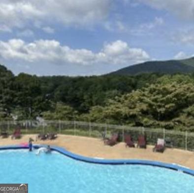 community pool featuring a mountain view and fence