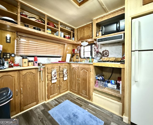 kitchen featuring open shelves, dark wood finished floors, light countertops, and freestanding refrigerator