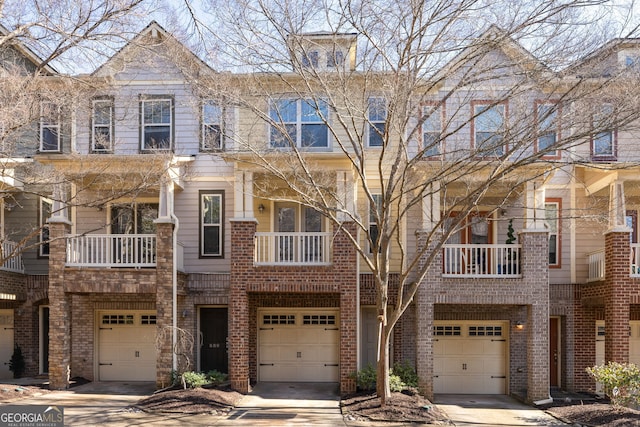 multi unit property featuring driveway, brick siding, and an attached garage