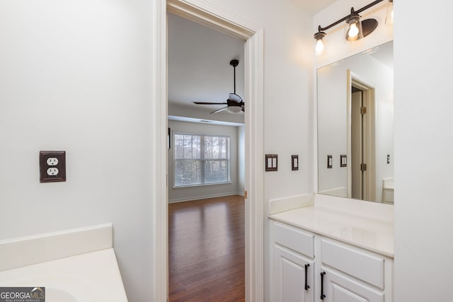 bathroom featuring ceiling fan, baseboards, wood finished floors, and vanity