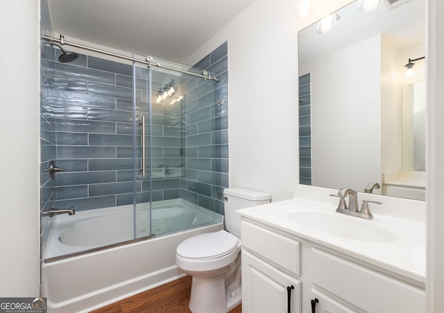 bathroom featuring shower / bath combination with glass door, vanity, toilet, and wood finished floors