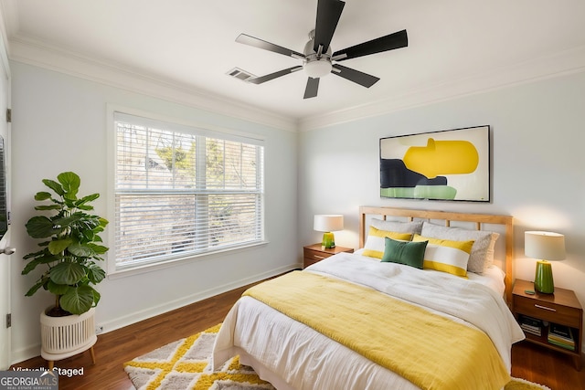 bedroom with baseboards, visible vents, ceiling fan, ornamental molding, and wood finished floors