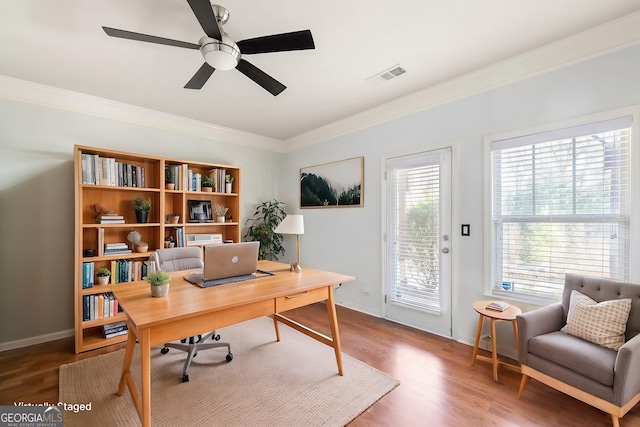 office area with wood finished floors, a ceiling fan, baseboards, visible vents, and crown molding