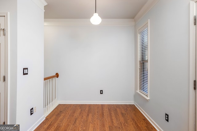 unfurnished room featuring baseboards, ornamental molding, and wood finished floors