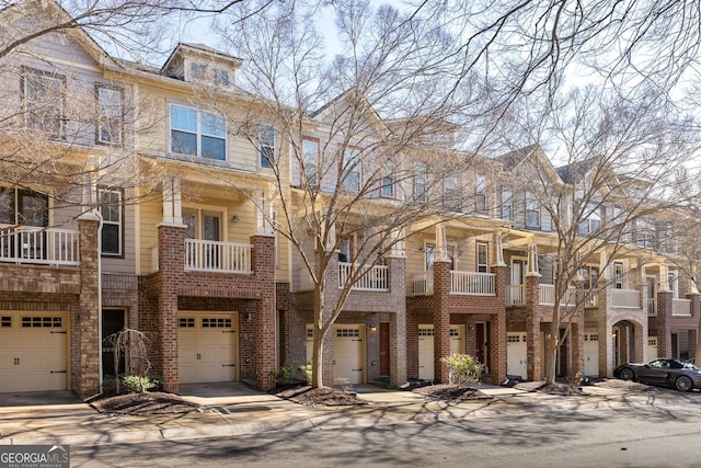 townhome / multi-family property featuring an attached garage, driveway, and brick siding