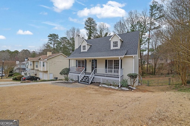 cape cod home with roof with shingles, a chimney, a porch, a front yard, and fence