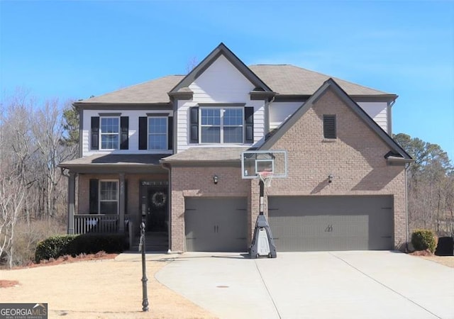 view of front facade featuring an attached garage, covered porch, driveway, and brick siding