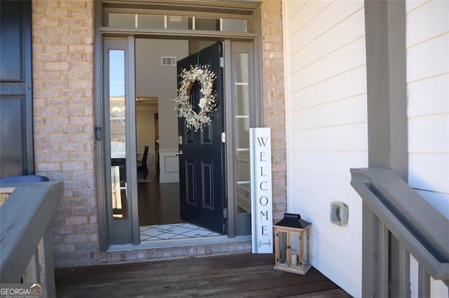 view of exterior entry with stone siding and visible vents