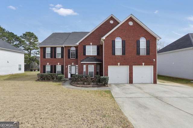 colonial inspired home featuring a garage, concrete driveway, brick siding, and a front yard