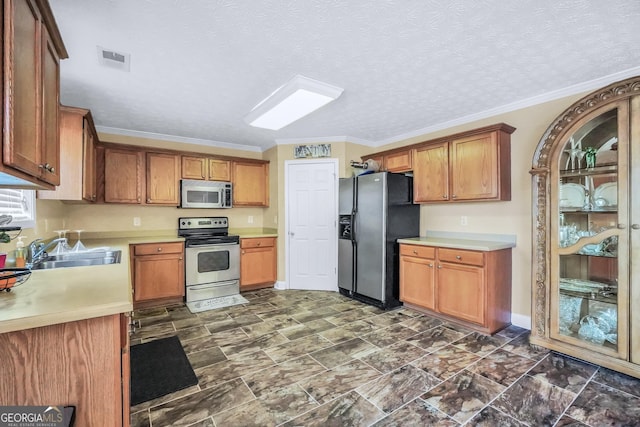 kitchen featuring crown molding, stainless steel appliances, light countertops, visible vents, and a sink