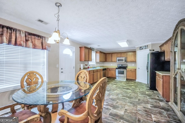 dining room with a chandelier, a wealth of natural light, visible vents, and a textured ceiling