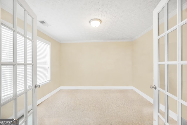 empty room featuring visible vents, baseboards, french doors, crown molding, and a textured ceiling