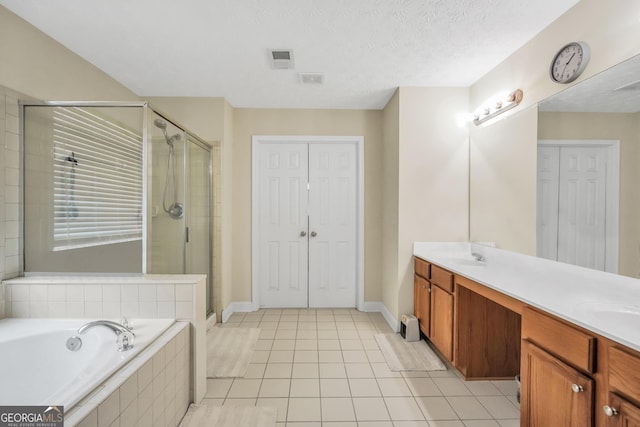 bathroom with double vanity, a garden tub, a shower stall, and tile patterned flooring