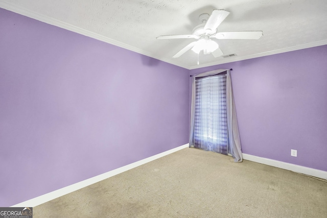 carpeted empty room with a textured ceiling, a ceiling fan, baseboards, visible vents, and crown molding