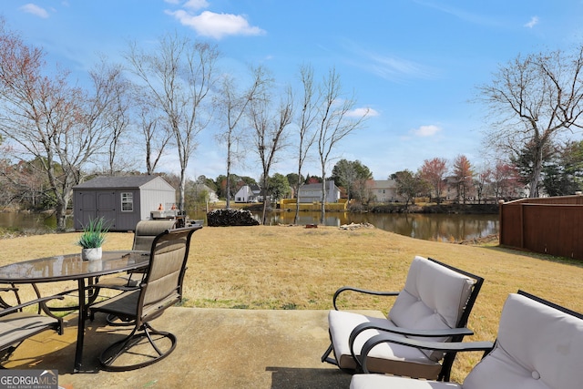 view of patio featuring a water view, an outdoor structure, and a shed