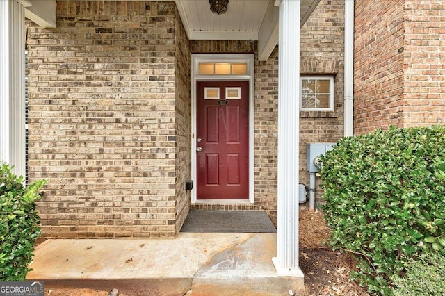 entrance to property featuring brick siding