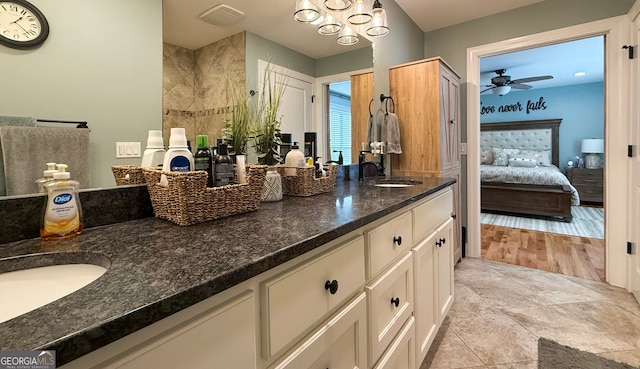 full bath featuring ensuite bathroom, double vanity, a sink, and a ceiling fan