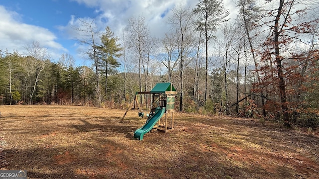 communal playground featuring a forest view