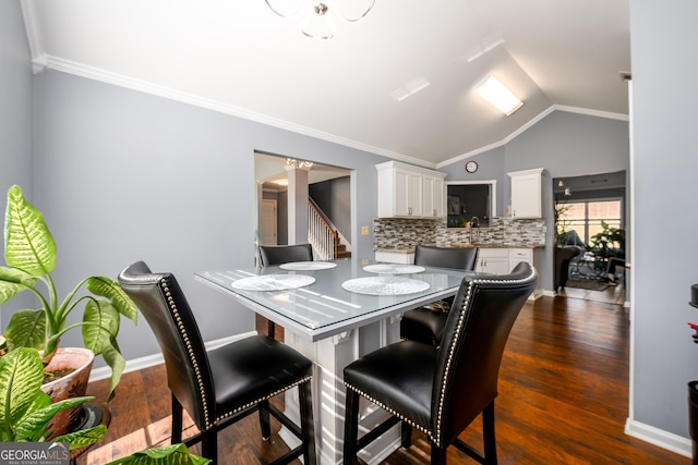 dining area with lofted ceiling, dark wood-style flooring, crown molding, and baseboards