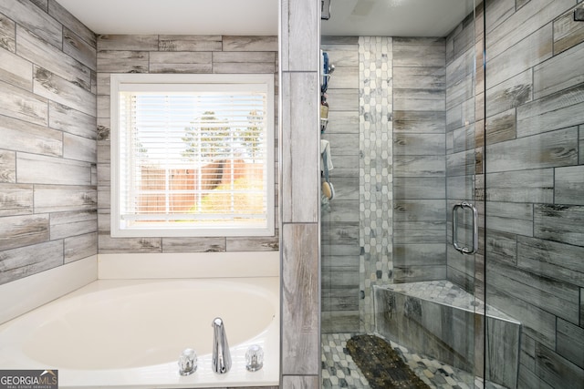 bathroom with a shower stall and a bath