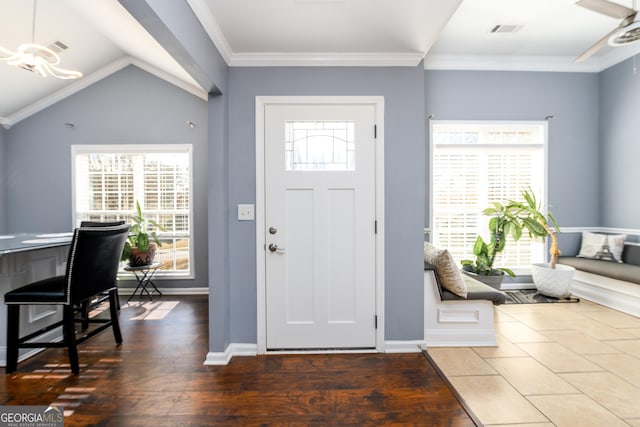 foyer featuring visible vents, crown molding, baseboards, and wood finished floors