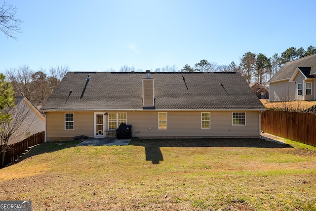 rear view of property featuring a fenced backyard, a yard, a chimney, and a patio