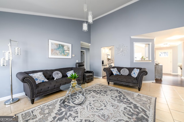 living room featuring ornamental molding, a towering ceiling, baseboards, and tile patterned floors